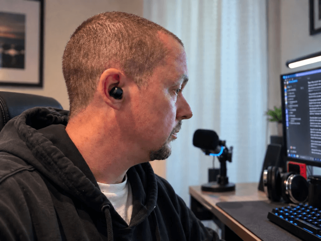 Tony Simons sitting at his workstation monitor in a black hoodie, evaluating software and AI systems